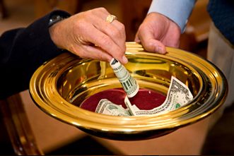 A picture of a golden offering plate full of dollar bills with a man's hand placing more inside.